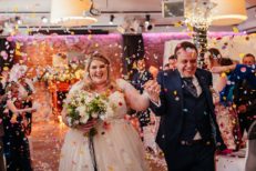 Bride and groom exit ceremony as colourful confetti is thrown