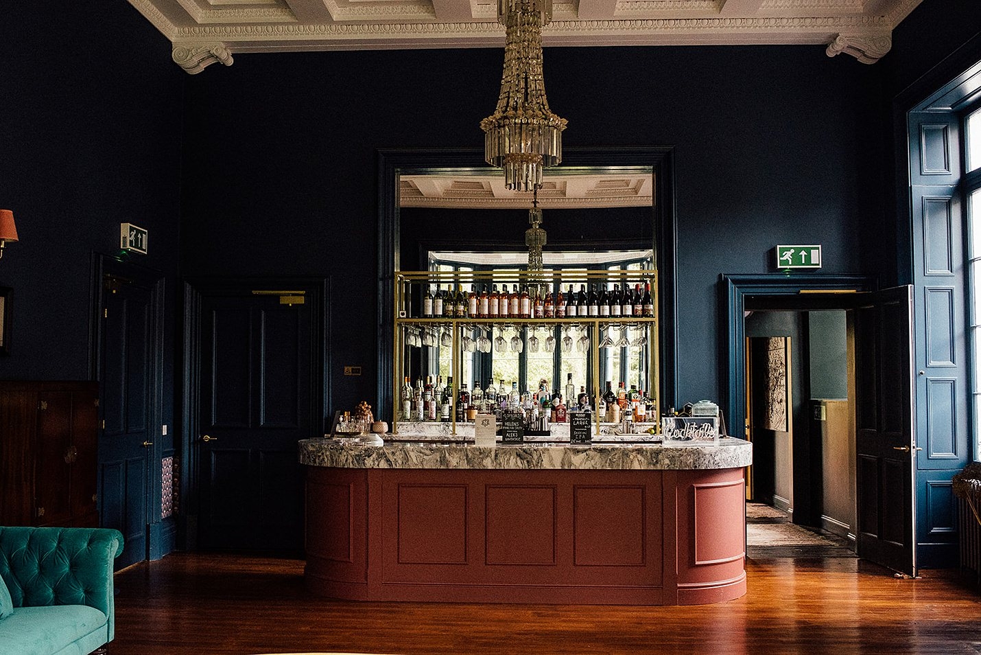 netherbyres house, wood panel bar, chandelier, matte navy walls, floor to ceiling mirror