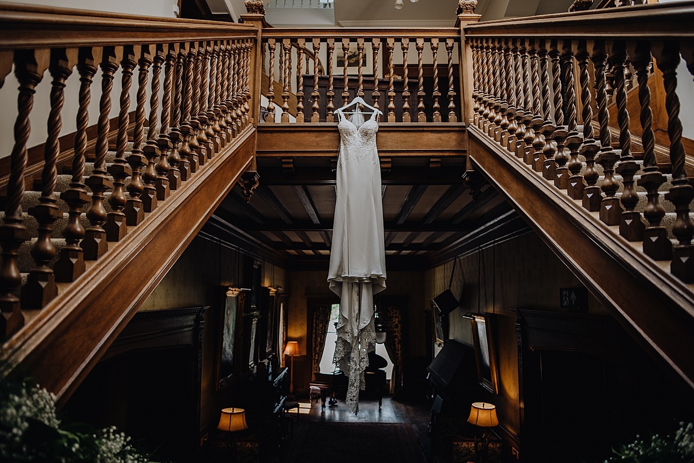 brides long white dress hanging from banister in venue hall martin vernham wedding photography