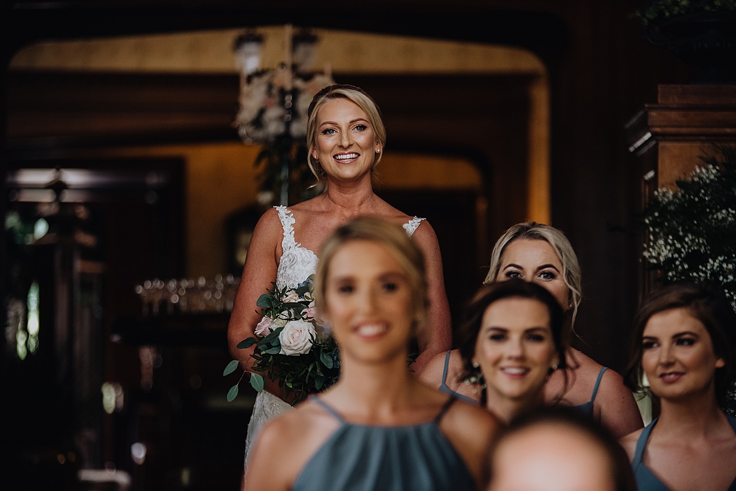 bride standing behind bridesmaids in venue grand hall before they walk out to ceremony sorn castle