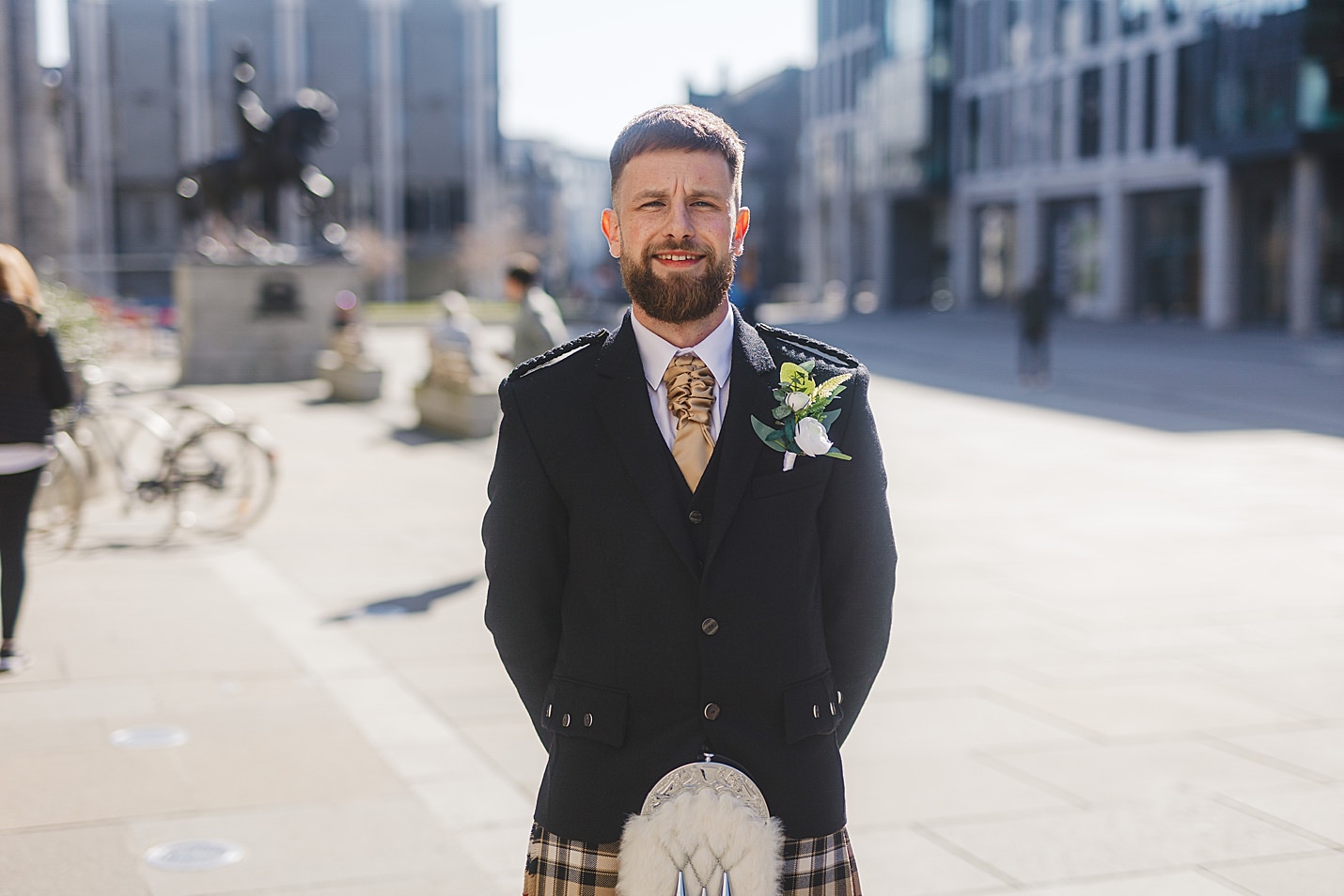 groom wearing full kilt outfit posing for camera in glasgow city centre marischal college wedding clarke joss photography