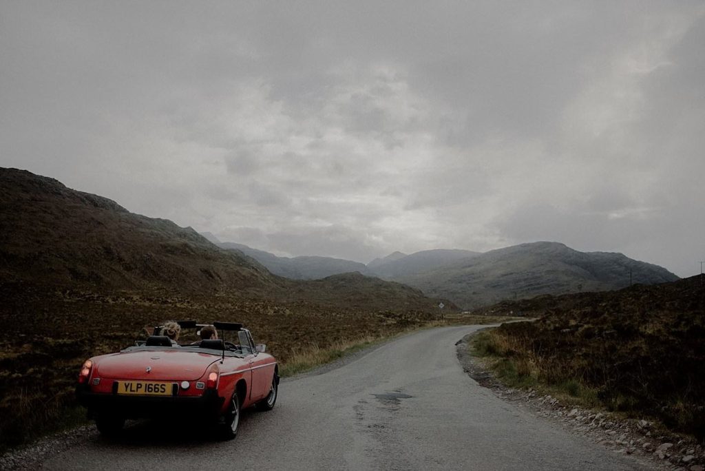 Couple elope to the Scottish Highlands in a vintage red MG